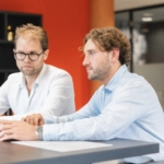 Twee mannen achter een laptop